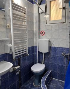 ein blau gefliestes Bad mit WC und Waschbecken in der Unterkunft Blue Orange Lake Hostel in Ohrid