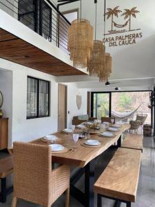 a dining room with a long wooden table and chairs at Casa junto al río en Bolombolo in Concordia