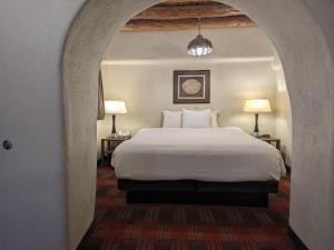 a bedroom with a white bed and two lamps at Sagebrush Inn & Suites in Taos
