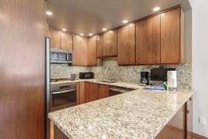 a kitchen with wooden cabinets and a granite counter top at Beeler Place 2 by Great Western Lodging in Frisco