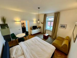 a bedroom with a bed and a living room with a table at Modern studio in the heart of the city in Maribor