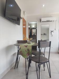 a dining room with a table and chairs and a television at Olivia View II in Ushuaia