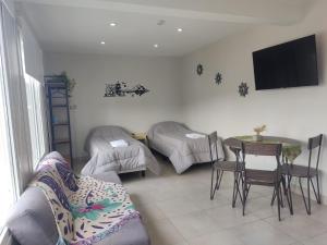 een woonkamer met een bank, een tafel en een tv bij Olivia View II in Ushuaia