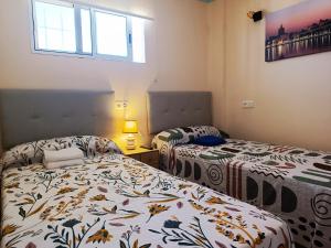 1 dormitorio con 2 camas y ventana en RIV - Reformado, Terraza con vistas al mar, 1 dormitorio, 800 metros de la Playa en Torremolinos
