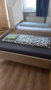 two beds in a room with wooden floors at Rheinischer Hof in Duisburg