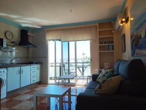sala de estar con sofá y cocina con balcón en RIV - Reformado, Terraza con vistas al mar, 1 dormitorio, 800 metros de la Playa en Torremolinos
