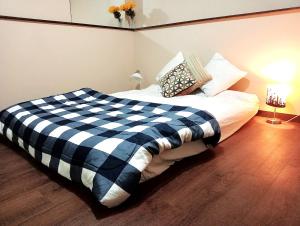 1 cama con manta a cuadros en blanco y negro en Beautiful Comfy & Relaxed Basement Room - Great Location C4 en Surrey