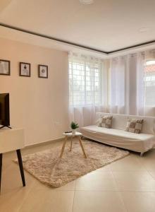 ein weißes Wohnzimmer mit einem Sofa und einem Tisch in der Unterkunft 24 hr Shuttle/transfer airport Quito in Quito