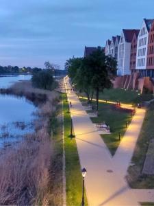 a city street with a river and buildings and trees at Apartament Przy Ratuszu in Malbork