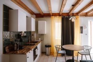 uma cozinha com mesa e cadeiras num quarto em Appart hôtel le 8 La Suite & Spa em Mâcon