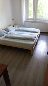 ein großes Bett in einem Schlafzimmer mit Holzboden in der Unterkunft Rheinischer Hof in Duisburg