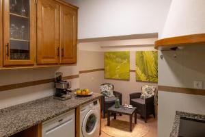 a kitchen with a washing machine and a living room at Elisabeth Holidays House in Costa da Caparica