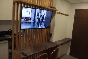 a flat screen tv sitting on top of a wall at Kitnet no Centro de Porto Alegre in Porto Alegre