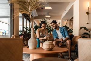 HiBird- Apartment and Suites Hotel في سان خوان: رجل وامرأة يجلسان على أريكة في غرفة المعيشة