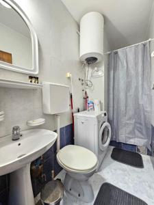 een badkamer met een toilet, een wastafel en een spiegel bij Studio Asli in Budva