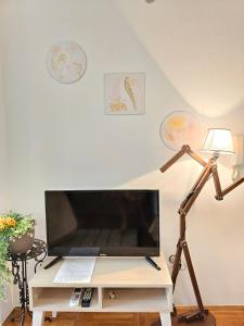 een woonkamer met een tv en een bureau met een lamp bij Studio Asli in Budva