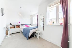 Habitación pequeña con cama y ventana en TMW guest house en Thamesmead