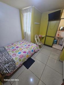 um pequeno quarto com uma cama e piso em azulejo em Su Majestad II em Huanta