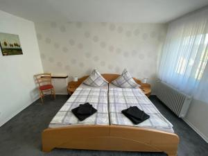 a bedroom with a bed with two black pillows on it at Ferienwohnung Becker in Ellenz-Poltersdorf
