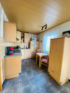 eine kleine Küche mit einem Tisch und einem Kühlschrank in der Unterkunft Ferienwohnung Becker in Ellenz-Poltersdorf