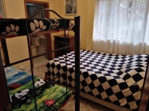 a bunk bed with a checkered blanket on it at Jamaica in Fusagasuga