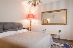 um quarto com uma cama com um espelho e um candeeiro em Il Cerretello - Tuscan Experience em Lucignano