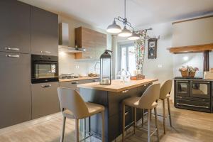 a kitchen with a counter with chairs and a island at Il Cerretello - Tuscan Experience in Lucignano