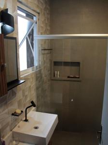 a bathroom with a sink and a shower with a window at Kitnet no Centro de Porto Alegre in Porto Alegre