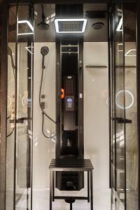 um chuveiro com um telefone numa caixa de vidro em Appart hôtel le 8 La Suite & Spa em Mâcon