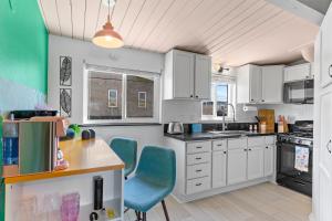 a kitchen with white cabinets and blue chairs at California Dreamin in Oceanside