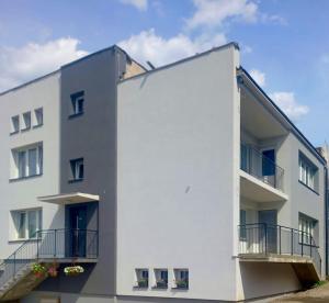 a white building with balconies on the side of it at DOBA RENT Wysockiego 104 in Białystok