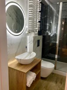 a bathroom with a sink and a toilet at DOBA RENT Wysockiego 104 in Białystok