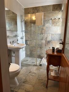 a bathroom with a shower and a toilet and a sink at Green Grove Guest House in St. Julianʼs