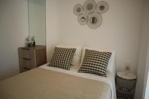 a bedroom with a bed with two pillows and a mirror at Merelia Luxury Guesthouse in Haraki