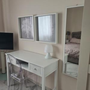 una scrivania bianca con sedia e specchio di Cascina Antiche Terre a Campegine