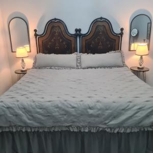 una camera da letto con un grande letto bianco con due lampade di Cascina Antiche Terre a Campegine