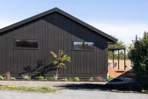 uma casa preta com duas janelas em The Corner on Te Mata em Havelock North