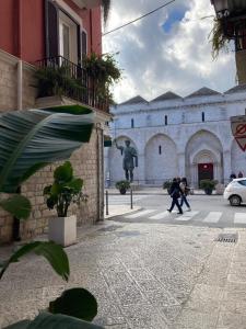 a group of people crossing a street in front of a building at Bell'Arè in Barletta +16 photos