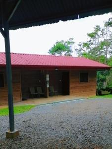 un bâtiment avec un toit rouge et une terrasse dans l'établissement Centro Ecológico La Ribera, à San Rafael