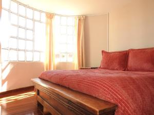 1 dormitorio con 1 cama con edredón rojo y ventana en SORACA MANTO REAL, en Soracá