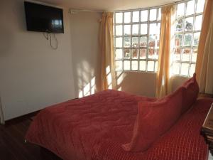 1 dormitorio con cama roja y ventana en SORACA MANTO REAL, en Soracá