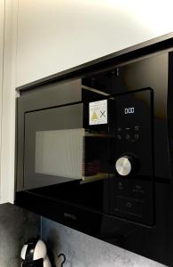 a black microwave oven with a sticker on it at Sétány Kuckó Apartman in Balatonfüred