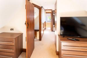 uma sala de estar com uma televisão de ecrã plano e uma cómoda em Barn Conversion in North Petherton em Bridgwater