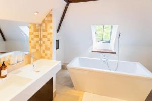 uma casa de banho branca com uma banheira e um lavatório em Barn Conversion in North Petherton em Bridgwater