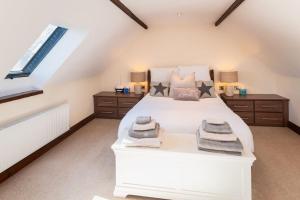 um quarto com uma cama branca e toalhas em Barn Conversion in North Petherton em Bridgwater
