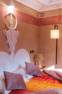 - une chambre avec un lit doté d'oreillers et d'un lustre dans l'établissement Riad Tourtit, à Imlil