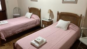 1 dormitorio con 2 camas y mesa con lámpara en La Escondida, Casa de Huéspedes en San Antonio de Areco