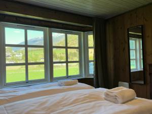 a bedroom with a bed and a large window at Flåm holiday home - mountain view - 1 km from Flåm in Flåm