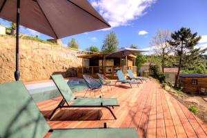 韦纳科Chalet U Pinu的泳池旁边有椅子和遮阳伞的甲板