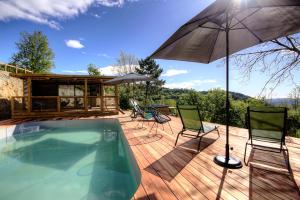 a patio with a swimming pool and an umbrella at Chalet U Pinu in Venaco